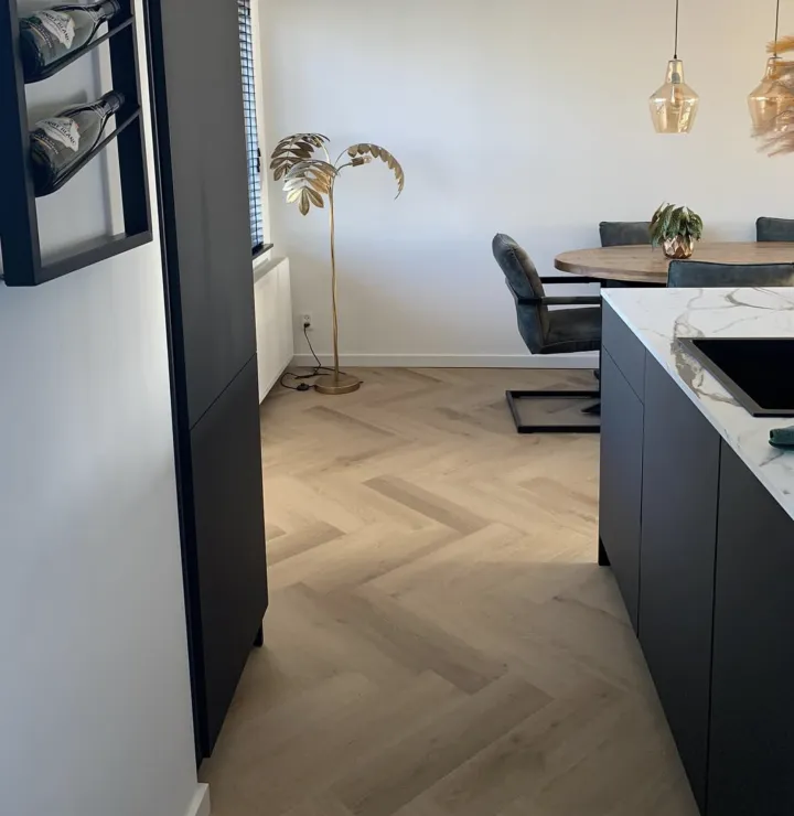 Lichte visgraatvloer in een keuken en eetkamer